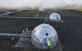 Carbfix domes are seen at the Hellisheidi power plant near Reykjavik on October 11, 2021. At the base of an Icelandic volcano, the newly-opened plant is sucking carbon dioxide from the air and turning it to rock, locking away the main culprit behind global warming. (Photo by Halldor KOLBEINS / AFP)