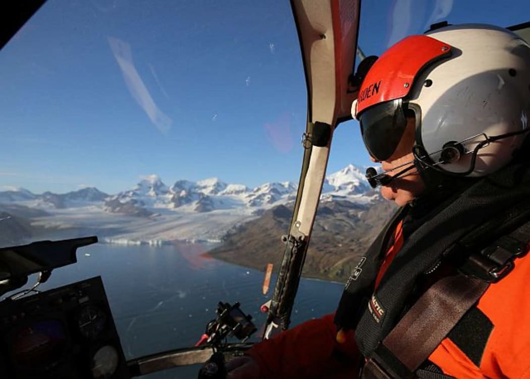 Chief pilot Peter Garden flying on South Georgia Island, with Nordenskjöld Glacier in the background.