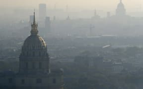 A photo taken on October 12, 2016 shows the domes of Les Invalides (L) and the Pantheon (R) in Paris seen through a veil of smog.