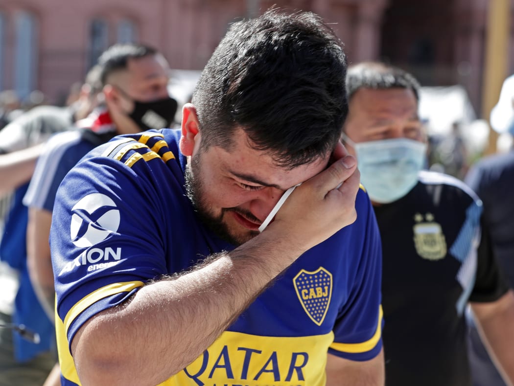 A fan mourns outside the Casa Rosada government house after paying tribute to Argentinian late football legend Diego Maradona,  Buenos Aires, 26 November 2020.
