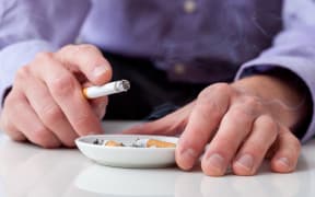 Man smoking cigarette and using an ashtray