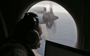 A crew member on a Royal Australian Air Force AP-3C Orion searches for missing Malaysia Airlines flight MH370 in the southern Indian Ocean in 2014.