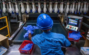 A worker inspects disposable gloves at the Top Glove factory in Shah Alam on the outskirts of Kuala Lumpur on August 26, 2020.
