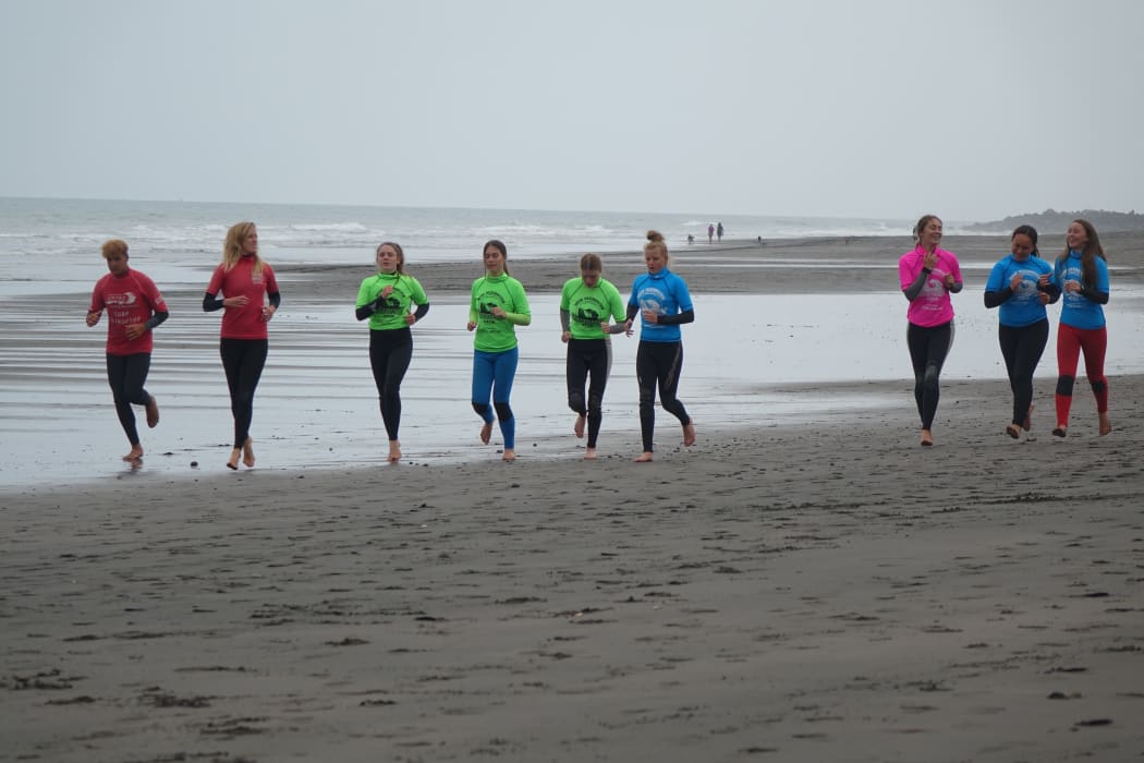 Otorohanga College Year 10 students warm up before a surfing session at Fitzroy Beach.