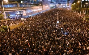 Thousands of protesters dressed in black take part in a rally against a controversial extradition law proposal in Hong Kong .
