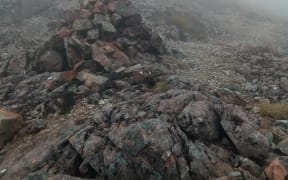 An image of a rock cairn, high on a ridge line, very useful for identifying the trail.