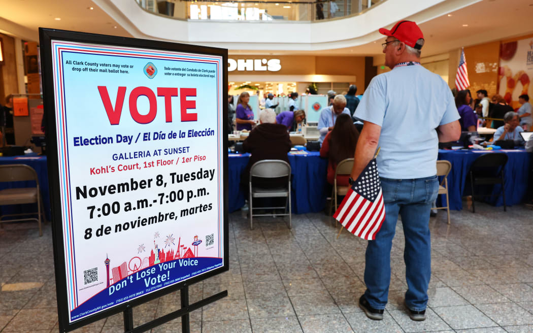 HENDERSON, NV – 8 NOVEMBRE: Un agent de vote tient un drapeau américain dans un bureau de vote à Galleria au coucher du soleil le 08 novembre 2022 à Henderson, Nevada.  Après des mois de campagne pour les candidats, les Américains votent aux élections de mi-mandat pour déterminer les races convergentes à travers le pays.  Mario Tama/Getty Images/AFP (Photo de Mario Tama/Getty Images Amérique du Nord/Getty Images via AFP)