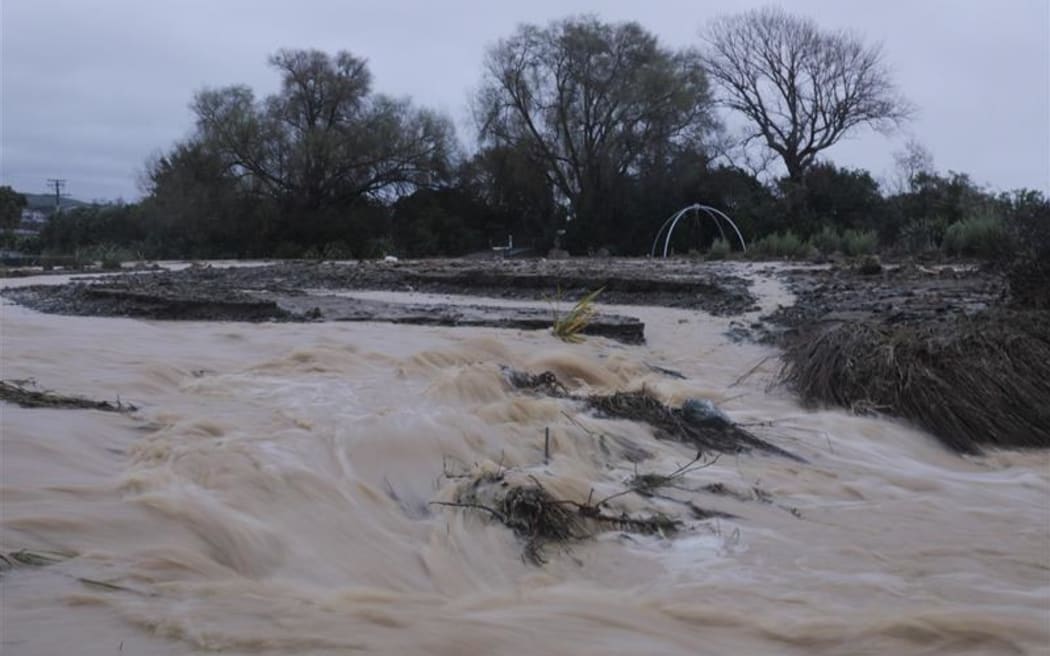 Raging water flows wash away debris and topsoil from the land in Nelson.