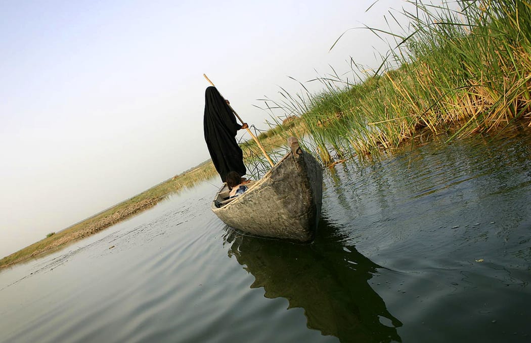 A veiled Iraqi woman rides in a boat as she goes out fishing early morning in marshland near Karbala, 110km south of Baghdad, in 2006.