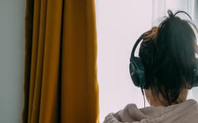 woman with headphones and grey hoodie