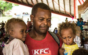 Families shelter at a Honiara evacuation centre.