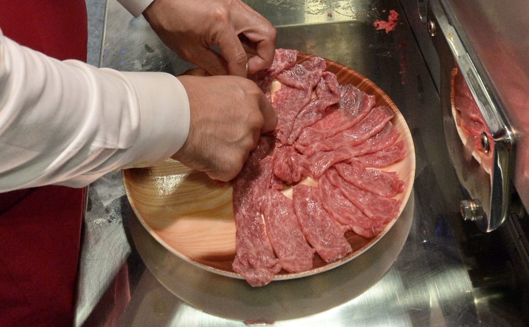 An exhibitor arranges machine sliced olive meat, a kind of wagyu beef at the Oiishi Japan food and beverages showcase in Singapore on October 16, 2014. AFP PHOTO/ROSLAN RAHMAN