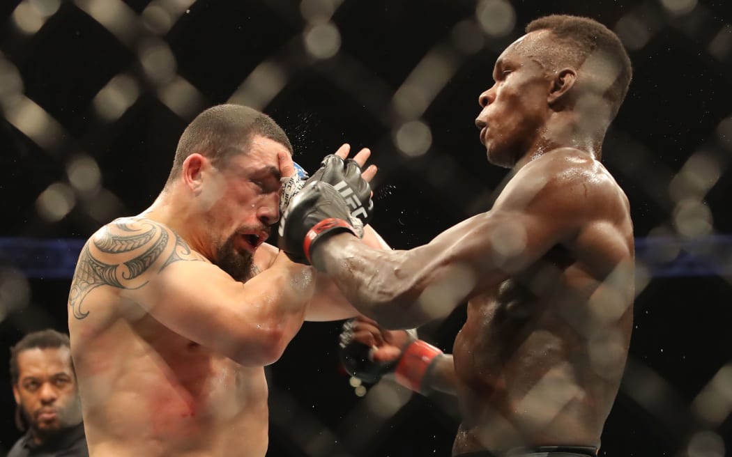 Israel Adesanya (R) exchanges with Robert Whittaker (L) en route to a unanimous decision victory on February 12 2022 at UFC 271 in Houston, Texas