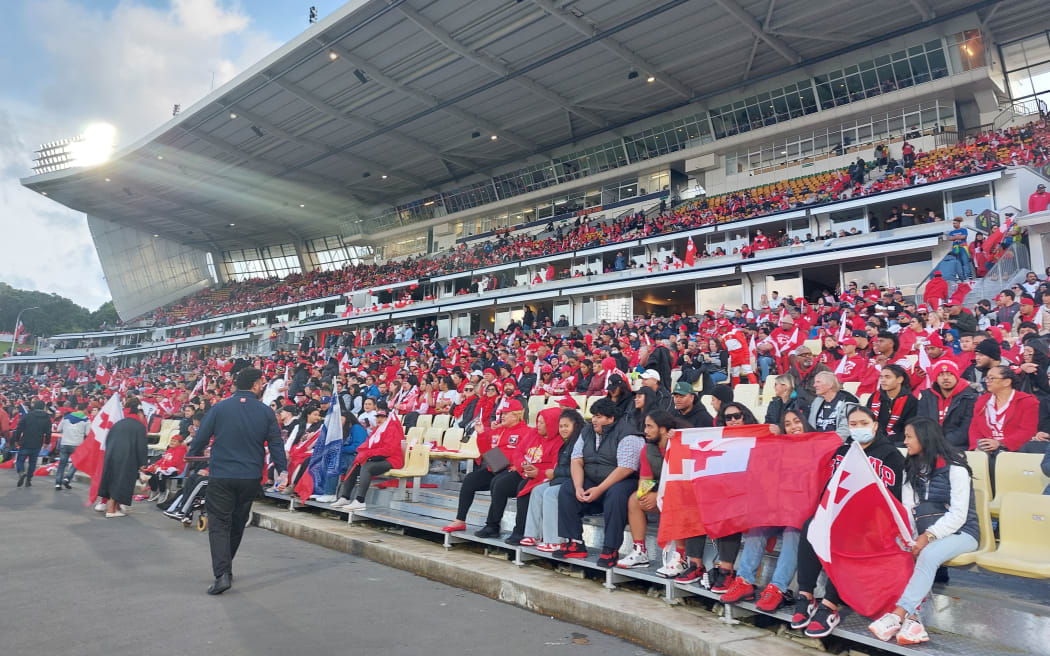 Fans wave the Tonga flag.