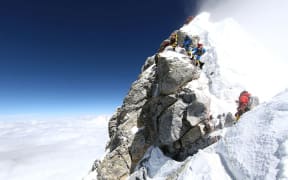 Unidentified mountaineers walk past the Hillary Step while pushing for the summit of Everest on May 20, 2011.