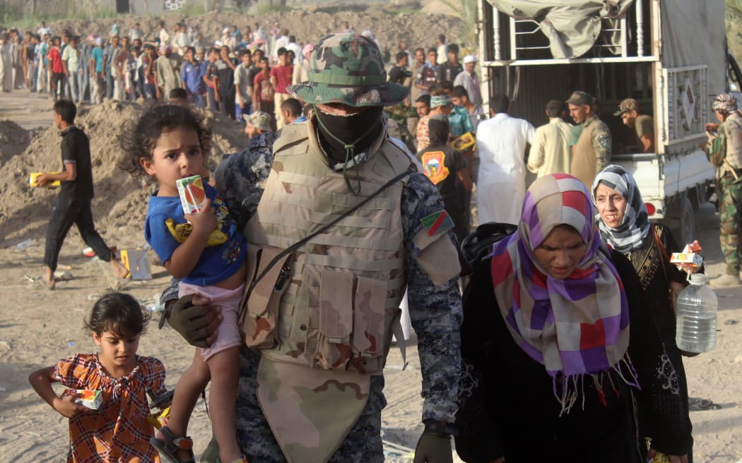 A displaced Iraqi family arrives at a safe zone on June 17, 2016 in Amiriyiah al-Fallujah, after Iraqi government forces evacuated civilians from the city of Fallujah due to their ongoing military operation to retake the city from the Islamic State (IS) group.