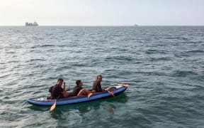 Three migrants who were attempting to cross The English Channel from France to Britain are seen as they drift in an inflatable canoe off the French coast at Calais on August 4, 2018, before being rescued.