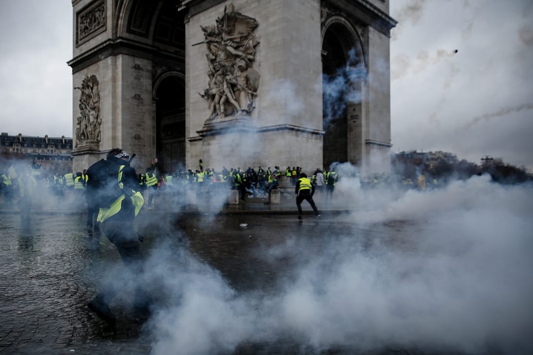 Demonstrators clash with riot police at the Arc de Triomphe during a protest of Yellow vests (Gilets jaunes) against rising oil prices and living costs.