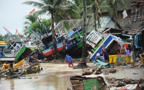 Fishermen tend to their traditional fishing boats which were damaged after being hit by a tsunami in the Teluk village, Labuan subdistrict in Banten province on 25 December, 2018.