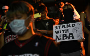 A protester holds a sign at the Southorn Playground in Hong Kong on October 15, 2019, during a rally in support of NBA basketball Rockets general manager Daryl Morey and against comments made by Lakers superstar LeBron James.