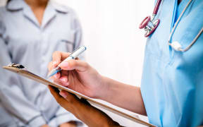 Doctor with clipboard takes patient's notes