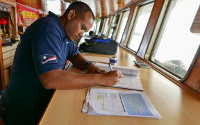 Fisheries officer Beau Bigler crosschecks ship documentation during the arriving vessel intelligence analysis for a purse seiner intending to gain authorization to transship its catch of tuna in Majuro. This is done for vessels intending to use port Majuro.