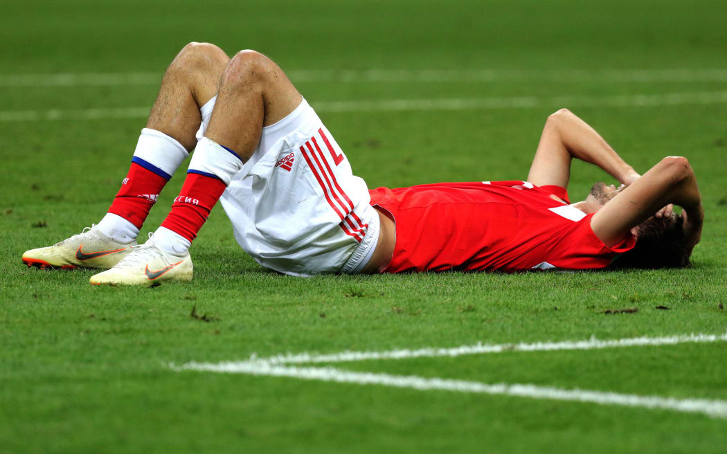 Russian player Aleksandr Erokhin lies on the ground in disappointment.