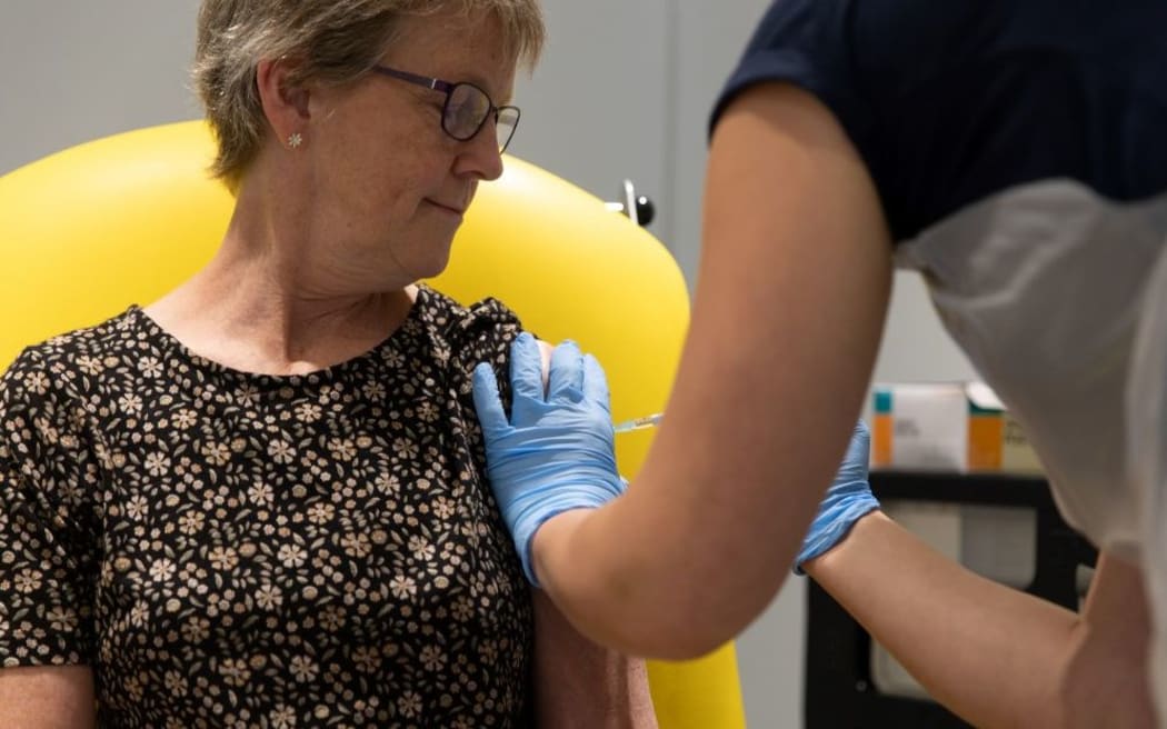 shows a health professional (R) administering a dose of the University's COVID-19 candidate vaccine, known as AZD1222, co-invented by the University of Oxford and Vaccitech in partnership with AstraZeneca, during its trial. -