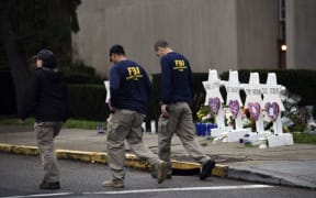 FBI officers walk past a memorial outside the Tree of Life synagogue in Pittsburgh after a shooting there left 11 people dead.