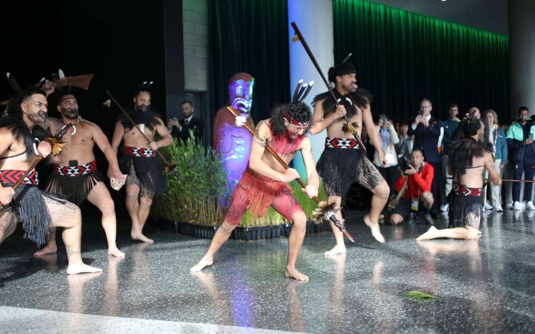 A warrior lays down a token in a wero (ceremonial challenge) for FIFA officials and the international football teams.