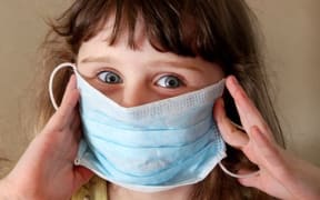 Child wearing flu mask