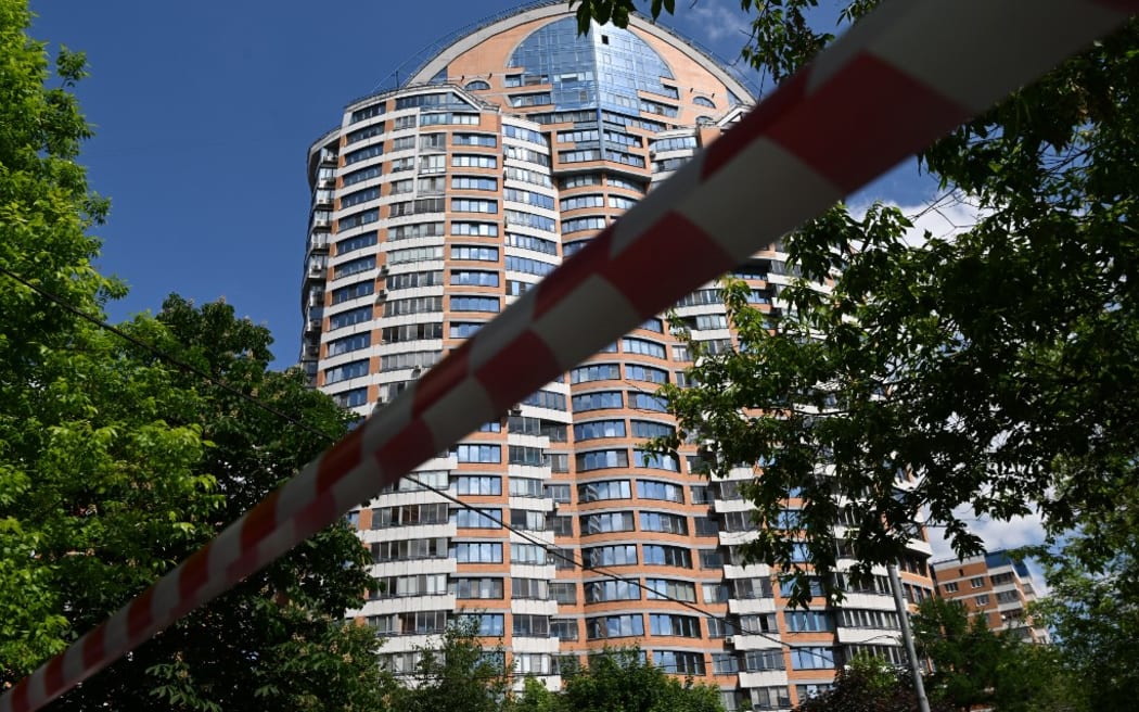 30 Mayıs 2023'te Moskova'da bir İHA saldırısı bildirildikten sonra polis bandı çok katlı bir apartmanın önünü kapattı (Fotoğraf: KIRILL KUDRYAVTSEV/AFP)