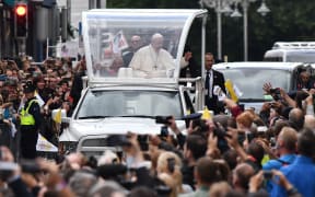 Pope Francis waves to the faithful on his popemobile in Dublin on August 25, 2018, during his visit to Ireland to attend the 2018 World Meeting of Families.