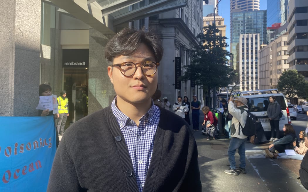 Aaron Lee, a New Zealand resident from South Korea attends protest at Consulate General of Japan building in Auckland.