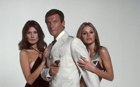 Roger Moore (c) as James Bond and his partners Maud Adams (l) and Britt Eklund (r) in "The Man with the Golden Gun" in 1974.