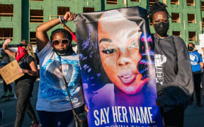 Two women hold a sign of Breonna Taylor during a rally on 18 September 2020 in Louisville, Kentucky.