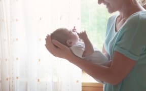 Woman holding newborn.