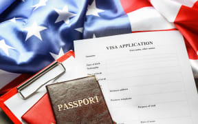 Passports, American flag and visa application form on table. Immigration to USA.