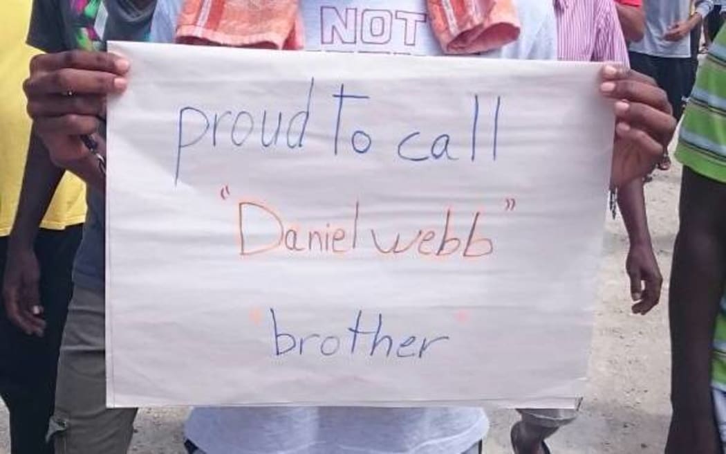 A Manus detainee holds a sign marking Mr Webb's award.