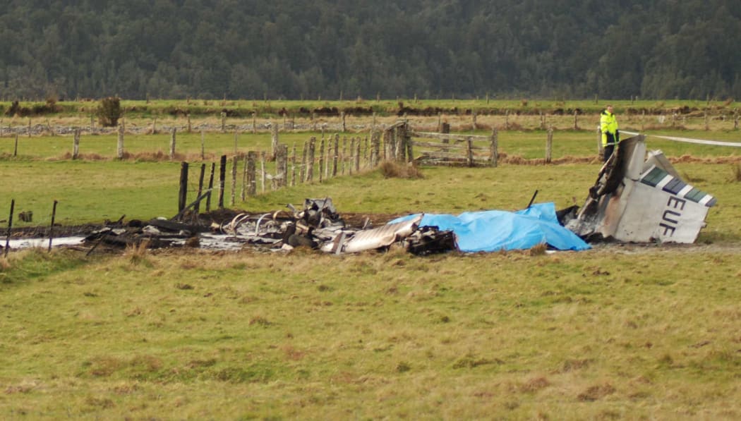 The wreckage of the crashed skydiving plane is seen at the end of the runway at Fox Glacier Airport on 4 September, 2010.