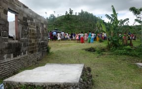 Navakawau villagers gather to watch aid being delivered
