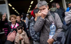 A refugee cries as he arrives at the main station in Dortmund, western Germany.