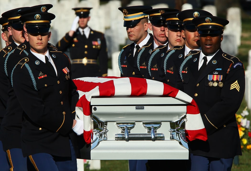 An honor guard carries the remains of four US soldiers who died in a helicopter crash in Iraq in 2009, at Arlington National Cemetery.