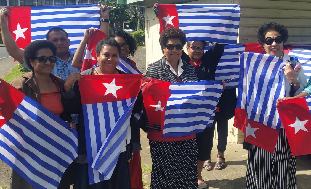 Ro Teimumu Kepa (centre) with staff flying the West Papua flag.
