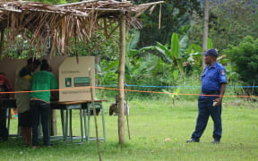 A police officer watches over polling in Papua New Guinea's election.