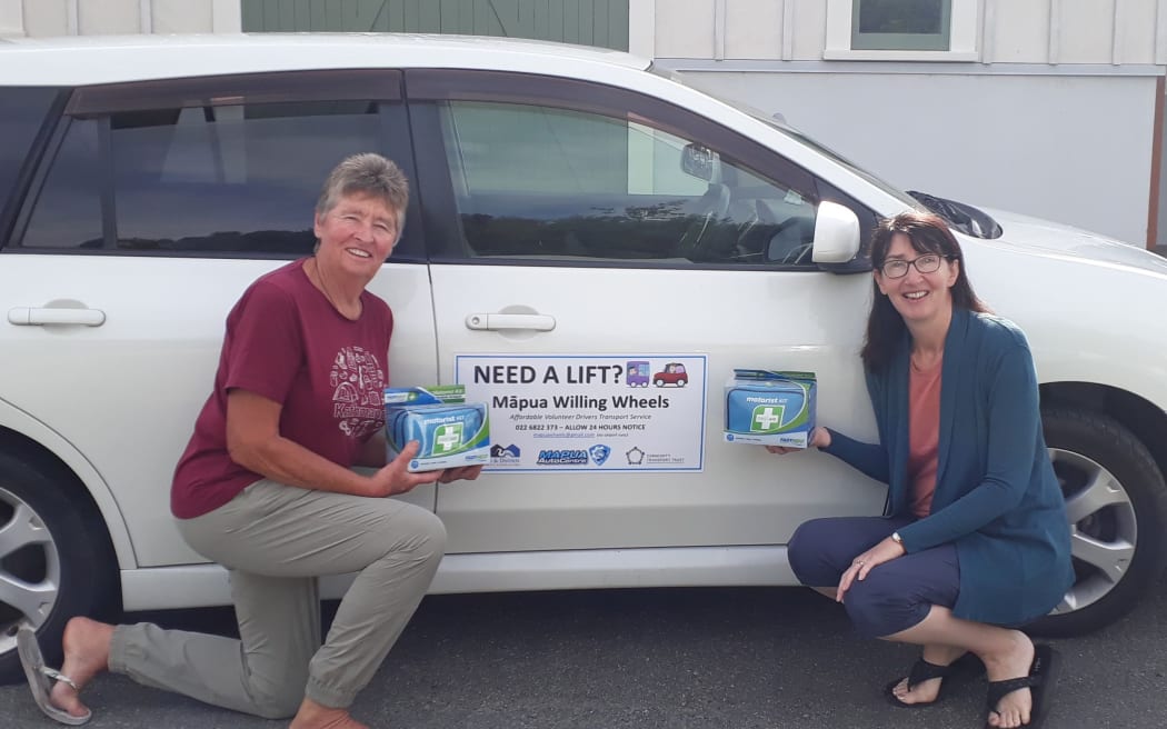 Nelson Tasman Community Transport Trust service co-ordinator Rachel Mason, right, with the Māpua Willing Wheels car, which people can book in order to access transport.