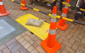Repair crews place a cover over a sinkhole which opened up on Manners Street in Wellington CBD after a pipe leak in the area on 5 December, 2023.
