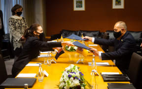Premier of Niue Dalton Tagelagi signing documents with New Zealand Prime Minister Jacinda Ardern