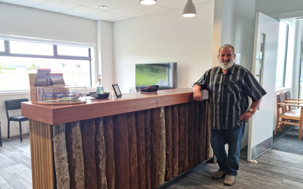 Robert Holmes standing by the museum counter he built