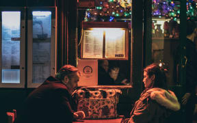 A couple sit in a dark bar